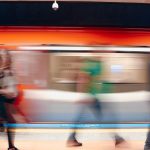 Dynamic scene of commuters in a subway station with motion blur capturing the rush.